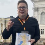 Arto holding a map of finland while conducting a tour