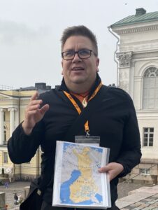 Arto holding a map of finland while conducting a tour