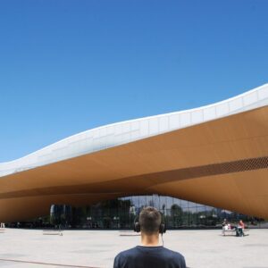 man listening to Arto´s audio tour while looking at the Oodi library