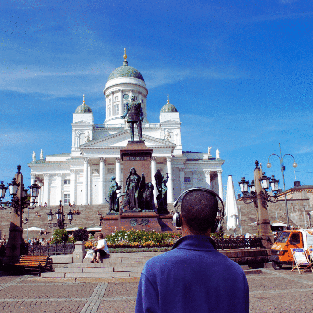 man walking on streets of Helsinki listening to Arto´s audio tour